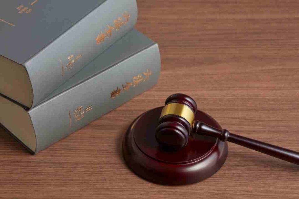 Gavel on a wooden desk next to two stacked law books.