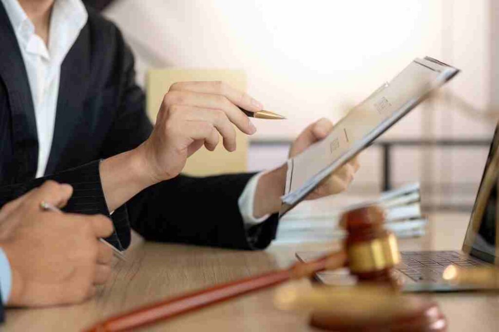 Close-up of lawyers discussing documents with a gavel on the table.